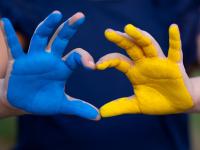 Hænder malet i gul og blå, som det ukrainske flag, former et hjerte (foto: shutterstock)